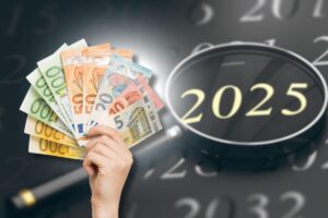 banconote euro in mano e calendario 2025 con lente