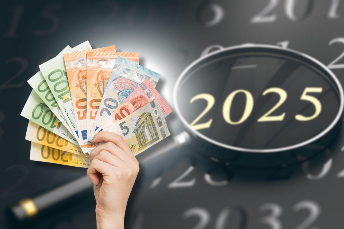 banconote euro in mano e calendario 2025 con lente